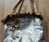 Классная серебристая сумка с золотыми деталями.
